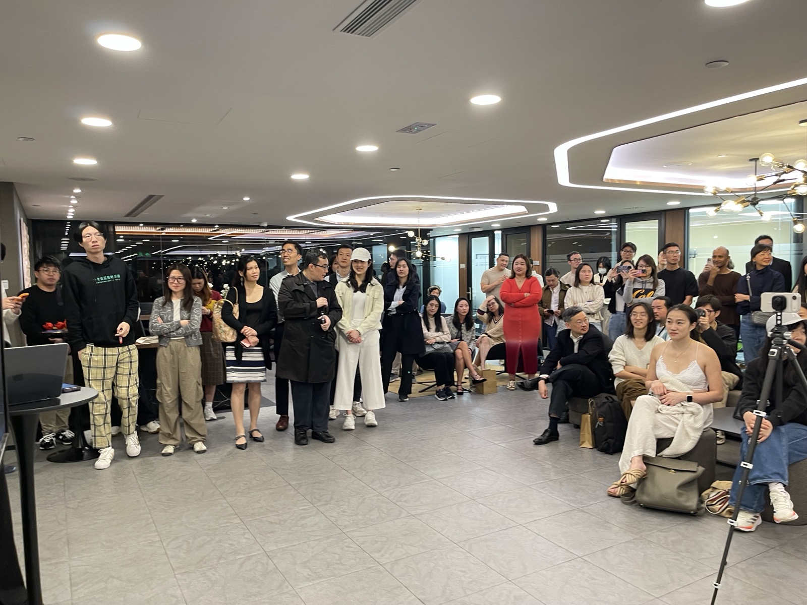 Standing crowd watching demos at Compass offices